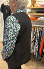 Back view of a black jacket with colourful floral patterned sleeves .