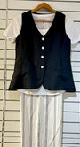 Black vest over a white shirt and striped pants .