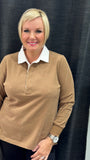 A person wearing a long-sleeved rugby top in a beige color with a white collar.
