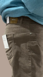 Person wearing a blue sweater and brown cord pants 