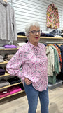 Woman wearing a pink patterned shirt i