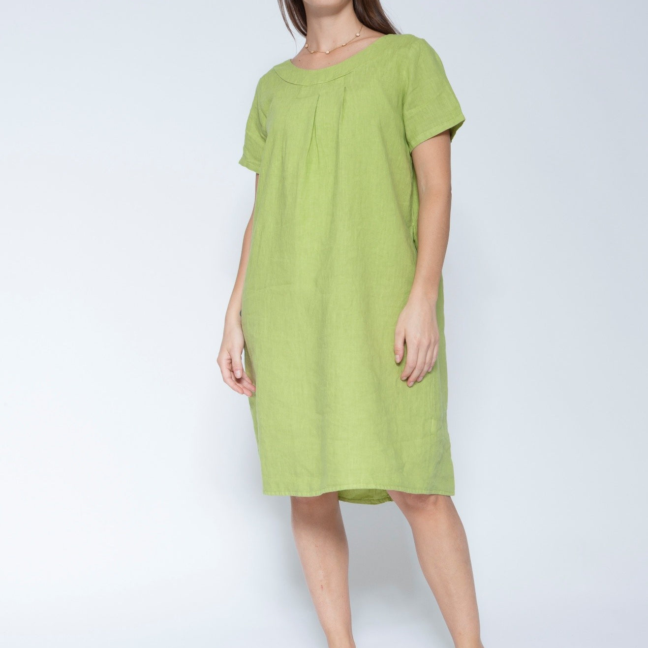 Front view short sleeve, knee length lime green linen dress against a light grey studio background.