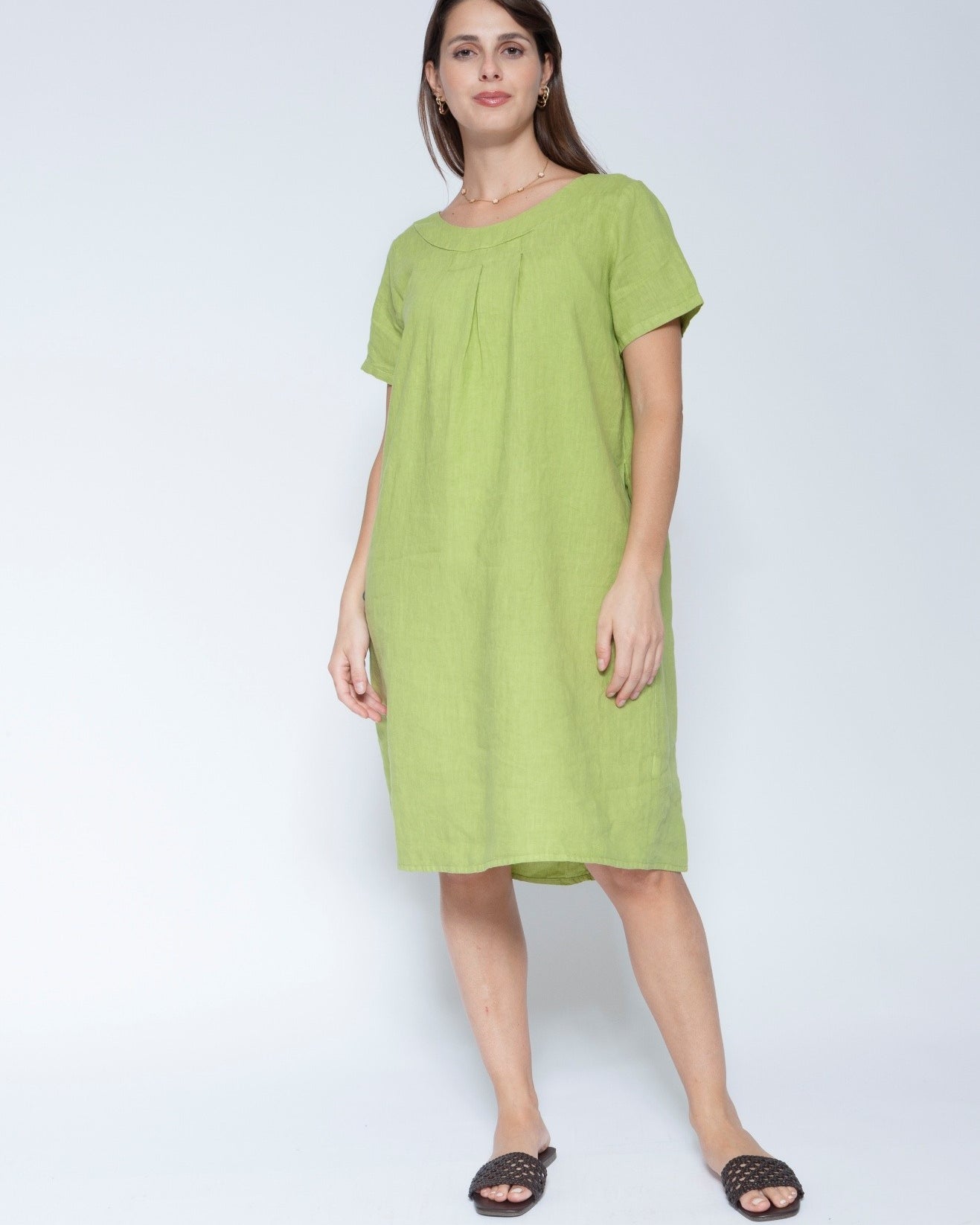 Front view short sleeve, knee length lime green linen dress against a light grey studio background.