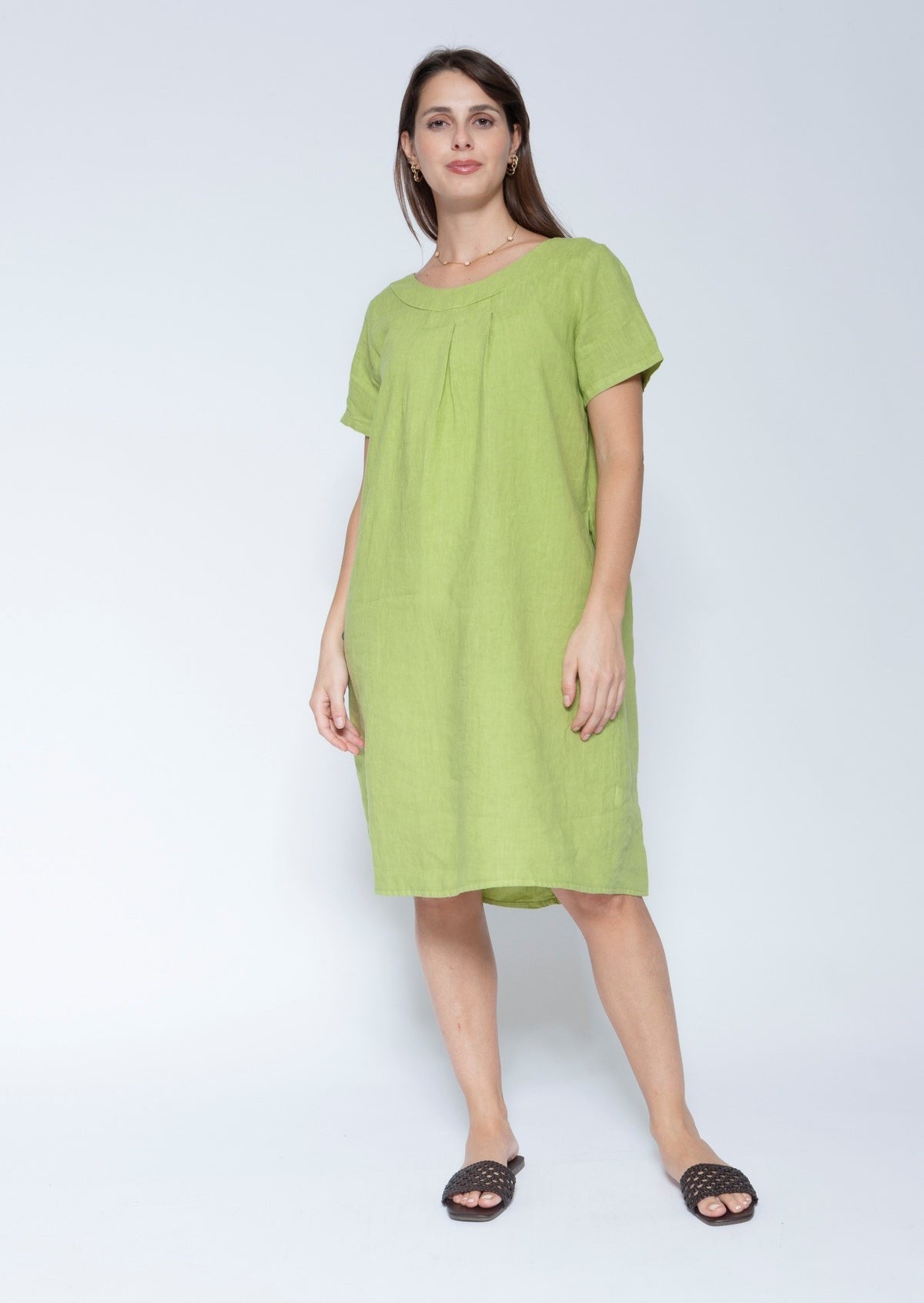 Front view short sleeve, knee length lime green linen dress against a light grey studio background.