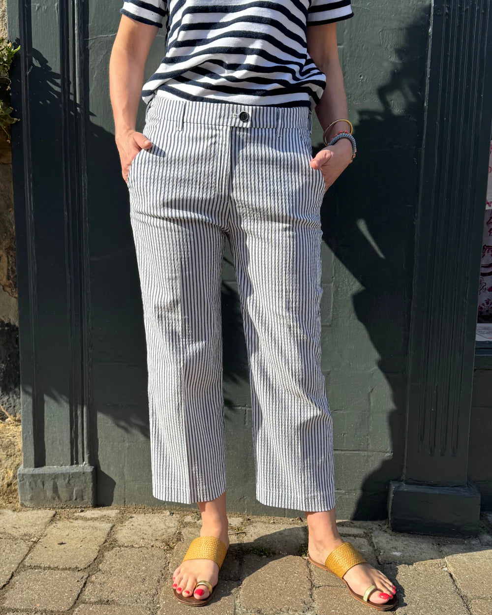 Person wearing a striped shirt and checkered pants front view.