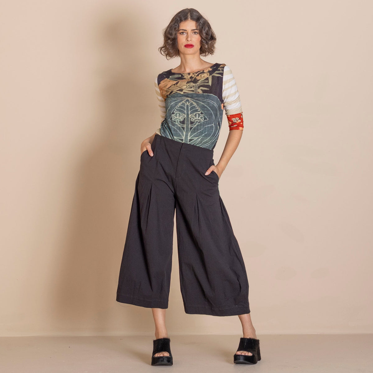 3/4 sleeve top with a graphic print and striped elbow section, paired with loose black wide leg cropped pants and black platform sandals.