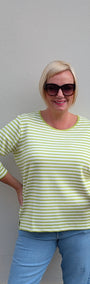 Front view  a green and white striped shirt and blue jeans .