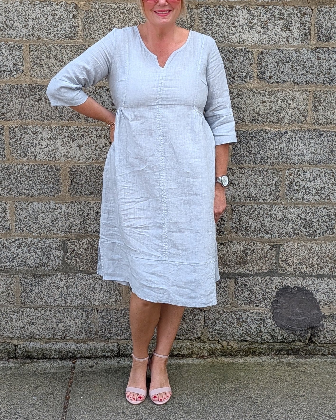 Front View of a light grey linen blend midi dress and pink sandals .