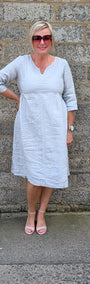 Front View of a light grey linen blend midi dress and pink sandals .