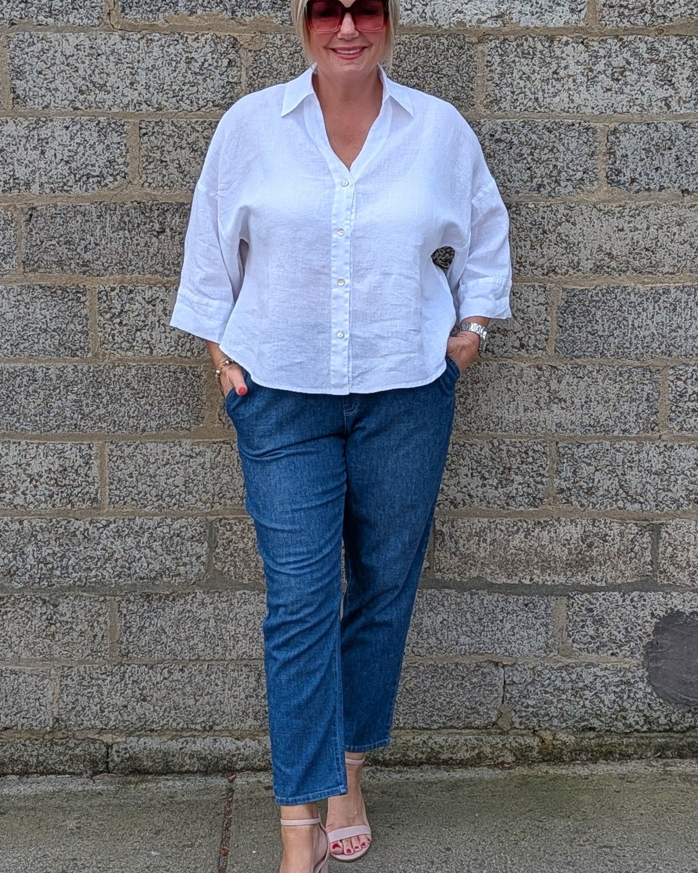 Front View of a white button-up shirt, blue jeans, and pink sandals.