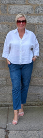 Front View of a white button-up shirt, blue jeans, and pink sandals.