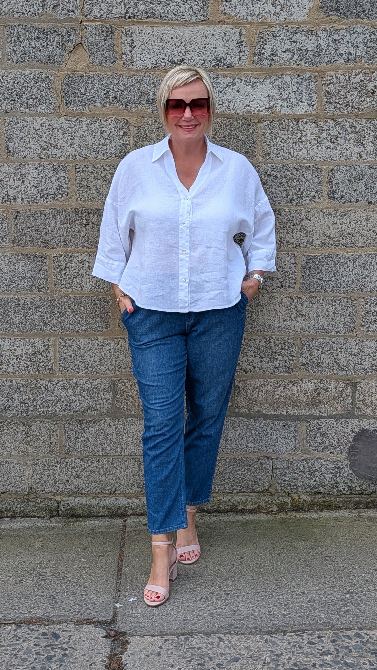 Front View of a white button-up shirt, blue jeans, and pink sandals.