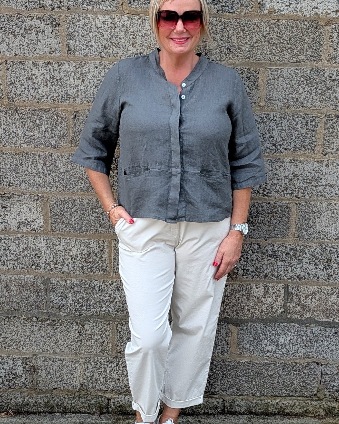 Front View a grey long sleeve button up shirt, off white cropped trousers, white sneakers.