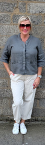 Front View a grey long sleeve button up shirt, off white cropped trousers, white sneakers.