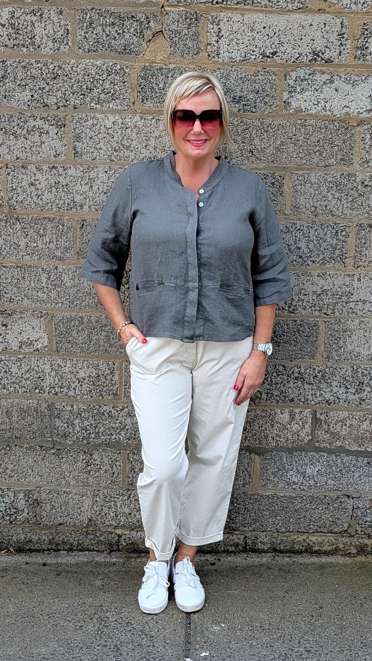 Front View a grey long sleeve button up shirt, off white cropped trousers, white sneakers.