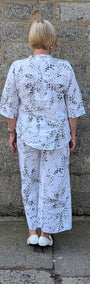  Back view  white two-piece pajama set with a black floral print.