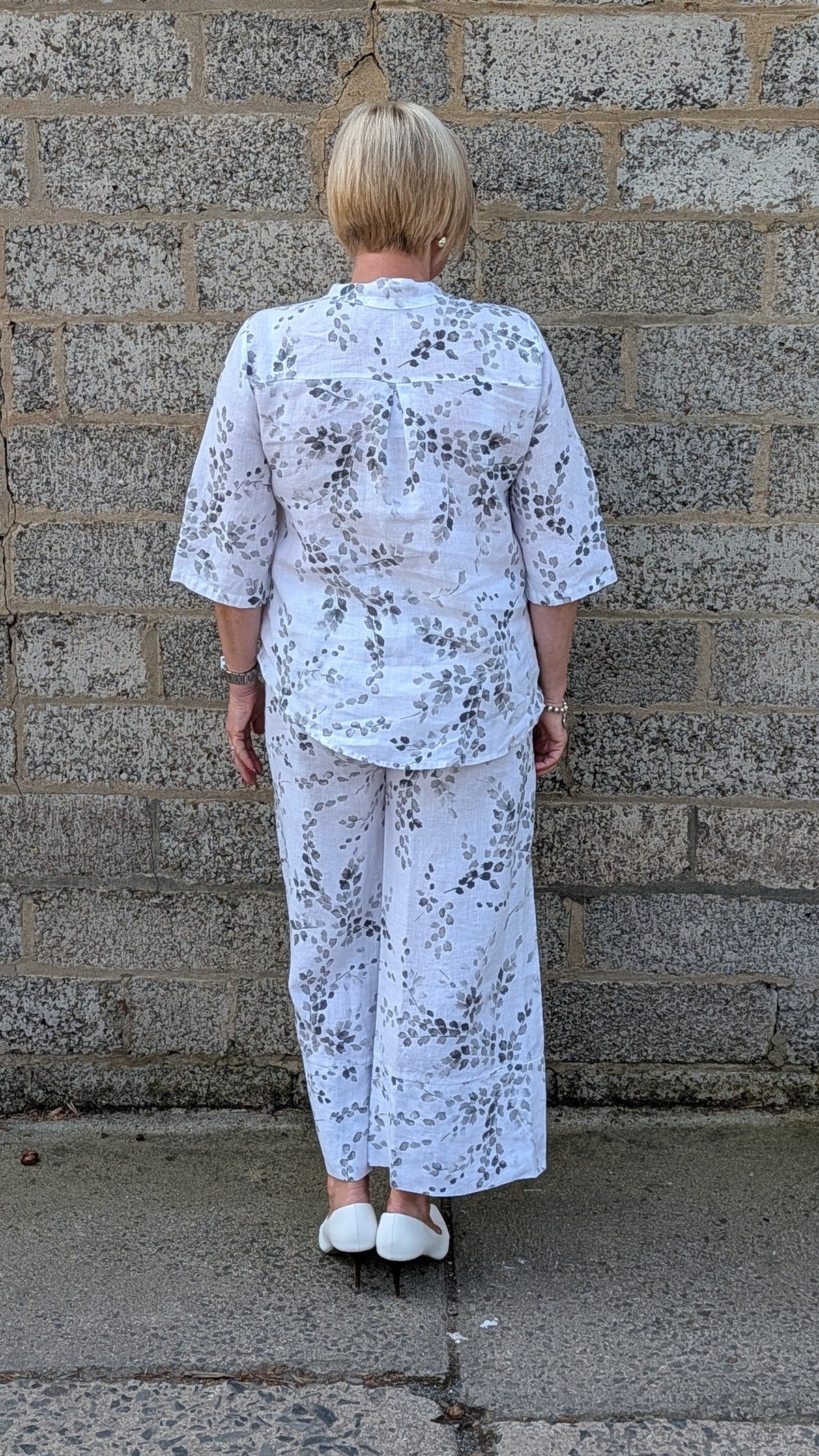  Back view  white two-piece pajama set with a black floral print.