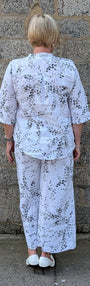 Back view of  a white two piece set with a black floral print.