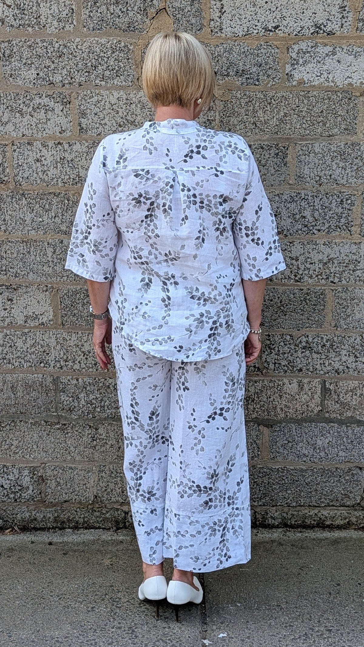 Back view of  a white two piece set with a black floral print.