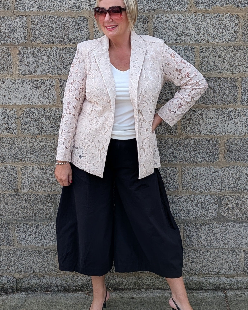 Lace Blazer by Two-Ts in Straw front view over a white top, black wide leg cropped pants, and black pointed heels.