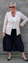 Lace Blazer by Two-Ts in Straw front view over a white top, black wide leg cropped pants, and black pointed heels.