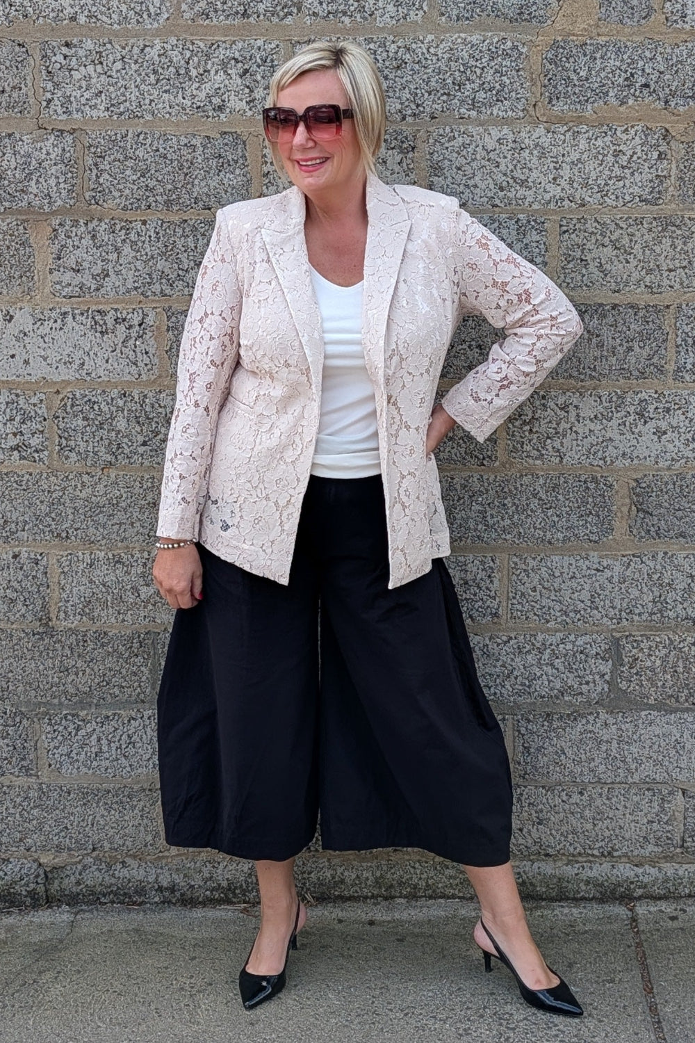 Lace Blazer by Two-Ts in Straw front view over a white top, black wide leg cropped pants, and black pointed heels.