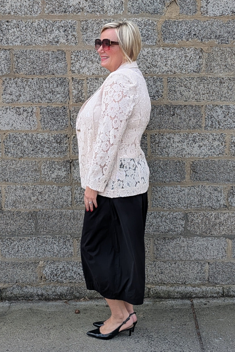 Lace Blazer by Two-Ts in Straw side view lace jacket, a black pant, and black heels.