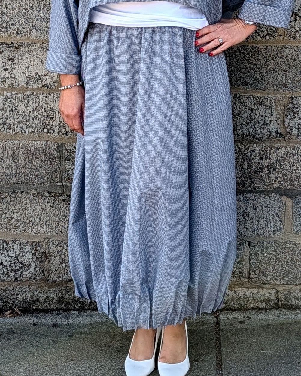 light blue grey striped maxi shirt dress with a white undershirt and white pointed-toe heels.