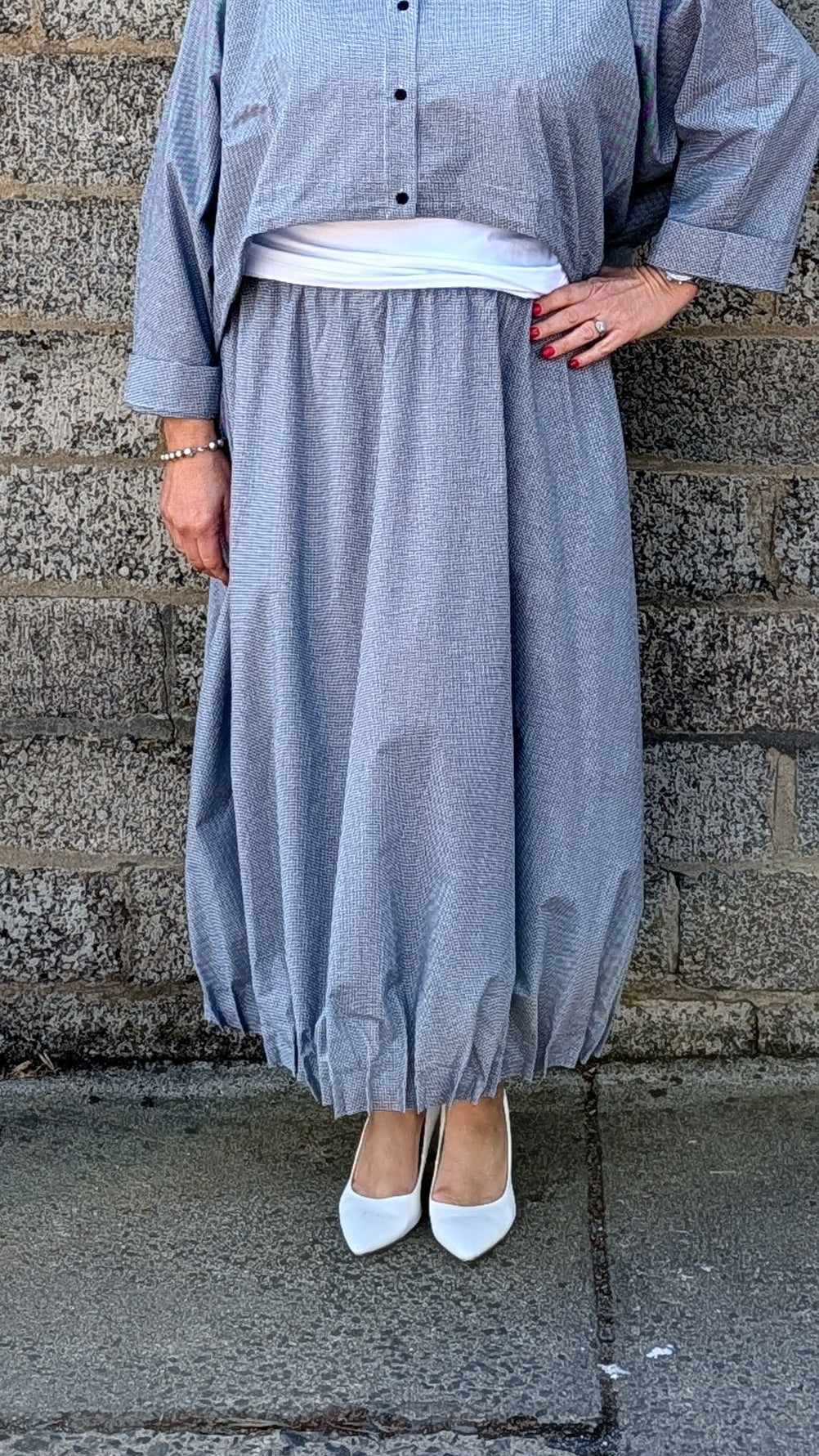 light blue grey striped maxi shirt dress with a white undershirt and white pointed-toe heels.