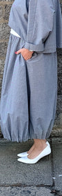light blue grey striped maxi shirt dress with a white undershirt and white pointed-toe heels.