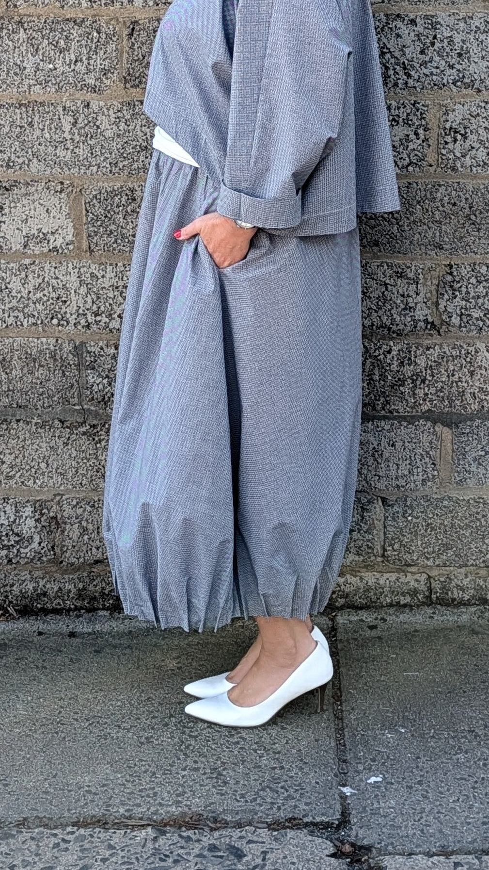 light blue grey striped maxi shirt dress with a white undershirt and white pointed-toe heels.