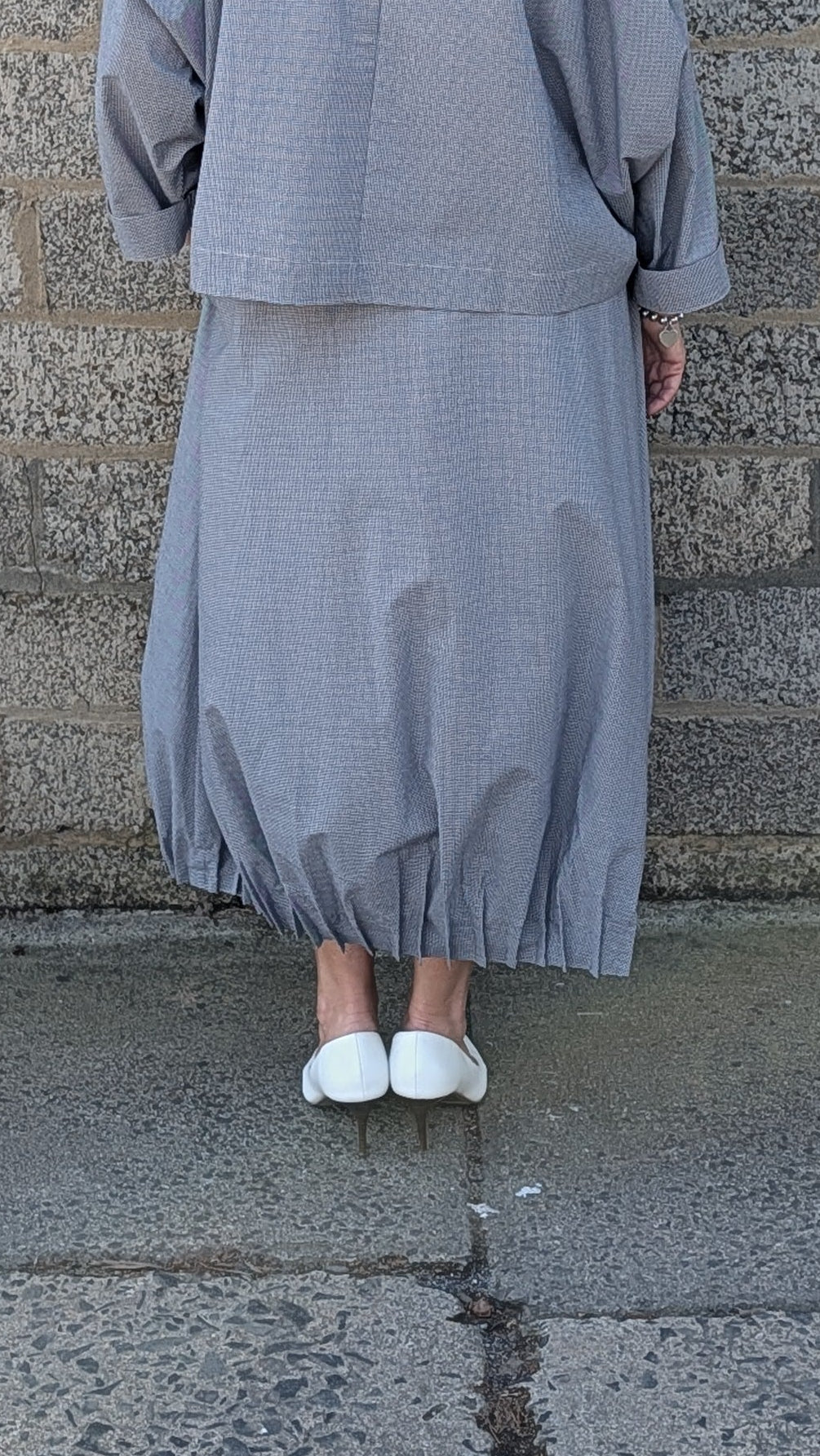 light blue grey striped maxi shirt dress with a white undershirt and white pointed-toe heels.