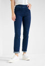 Front view  a pink long sleeve top and blue jeans with a high waist and slim fit. She is also wearing a pair of tan shoes 