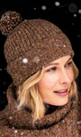 A person wearing a brown flecked bobble beanie with a pom-pom on top, 