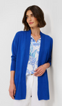 A woman wearing a blue knit cardigan with a floral pattern on the sleeves and a viscose-linen mix fabric.