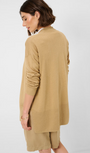 Back view  woman wearing a sand knit cardigan with a white shirt .