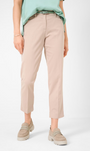 Front view   beige colored pants with a tapered leg and a wide waistband, paired with a light green blouse and tan flat shoes.