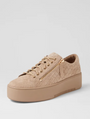 Beige sneaker with quilted design and gold zipper on a light gray background