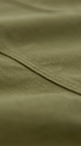 Close-up of olive green fabric with a visible seam