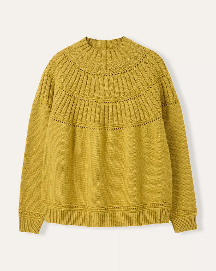 Mustard yellow sweater on a light beige background