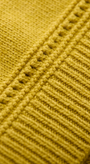 Close-up of a yellow knitted fabric with a textured pattern