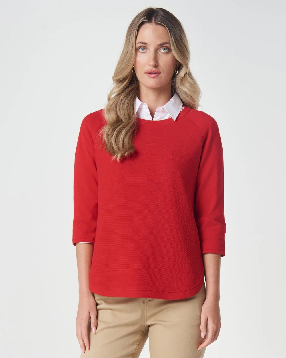  bright red 3/4 sleeve crewneck sweater, styled over a white collared shirt and beige trousers.