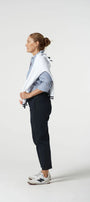 Person wearing a white shirt with blue stripes, dark pants, and white sneakers on a white background
