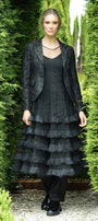 Woman wearing a black outfit with a layered skirt in a garden setting