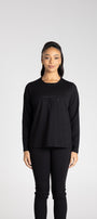 Person wearing a black long-sleeve shirt and black pants on a white background