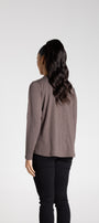 Person wearing a long-sleeve top and black pants on a white background