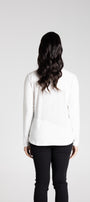 Person wearing a white blouse and black pants on a plain background
