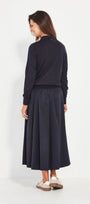 Woman wearing a dark blue top and skirt on a white background