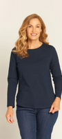 Woman wearing a navy long-sleeve top and jeans on a beige background