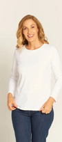 Woman wearing a white long-sleeve top and blue jeans against a plain background
